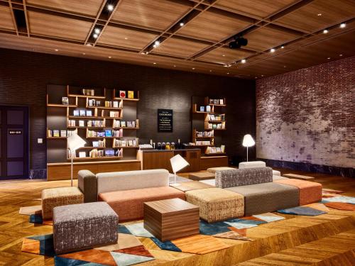 a living room with a couch and chairs and bookshelves at IN THE LIBRARY hotel and books TOKOROZAWA - Opening in 15th July 2025 in Tokorozawa