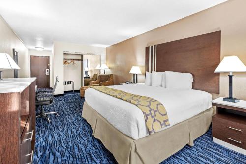 a hotel room with a large bed and a desk at Baymont by Wyndham Port Arthur - Groves Area in Port Arthur