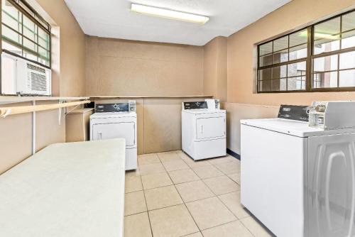 a laundry room with washers and dryers at Baymont by Wyndham Port Arthur - Groves Area in Port Arthur