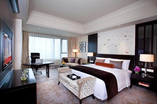 a bedroom with a large bed and a living room at InterContinental Wuxi by IHG in Wuxi