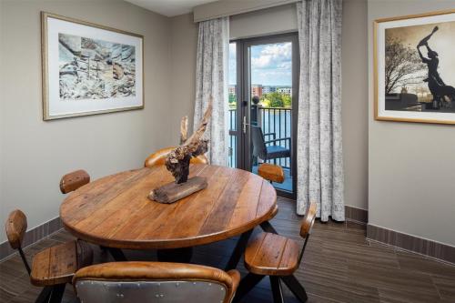a dining room with a table and chairs and a balcony at Homewood Suites Savannah Historic District/Riverfront in Savannah