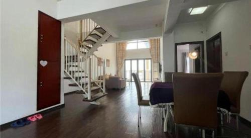 a living room with a staircase and a table and chairs at The Century Seaview Hotel in Shenzhen
