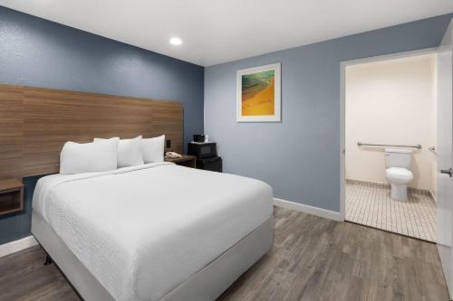 a hotel room with a bed and a bathroom at Days Inn by Wyndham Arroyo Grande Pismo Beach in Arroyo Grande