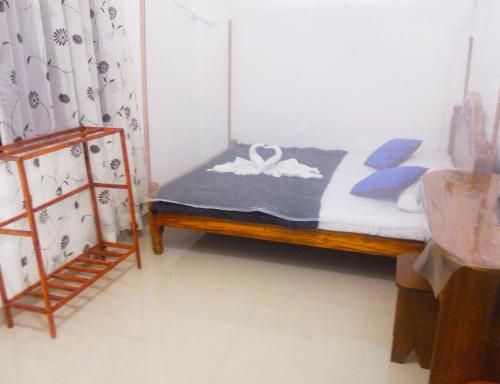 a bedroom with a bed with blue and white sheets at 20 House Arugam in Arugam Bay