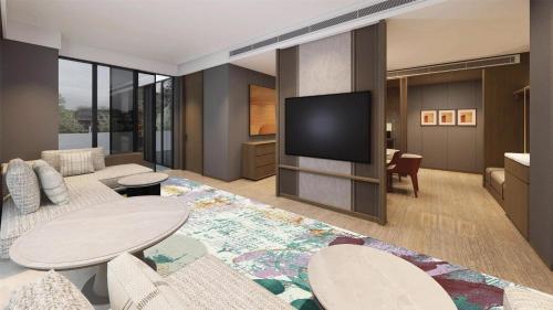 a living room with a tv on a wall at DoubleTree by Hilton Jakarta Kemayoran in Jakarta