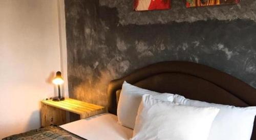 a bed with a headboard and a lamp on a table at Sritrang Hotel in Trang