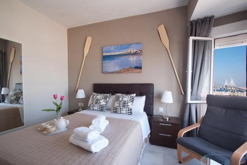 a bedroom with a bed and a chair and a window at Apartment Altavista in Cádiz