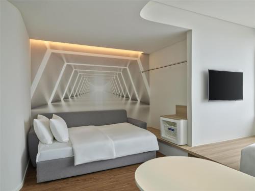 a living room with a couch and a tv at Tru by Hilton Nam Dinh City Centre in Nam Ðịnh