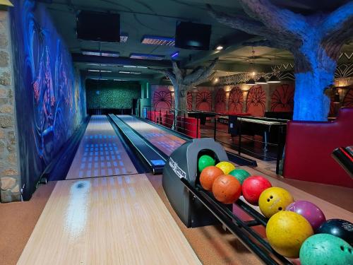 a bowling alley with pins and balls on the lanes at Hotel Kasztel in Rzezawa