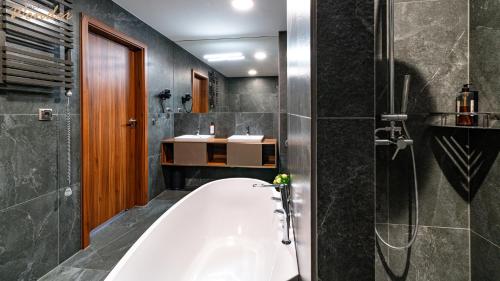 a bathroom with a bath tub and a sink at Wonder Hill - bajkowy widok na góry i zalew in Sosnówka