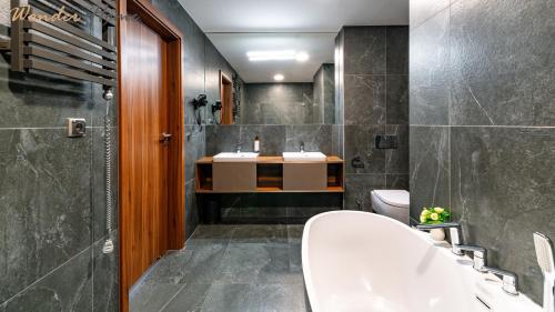 a bathroom with a white tub and a sink at Wonder Hill - bajkowy widok na góry i zalew in Sosnówka