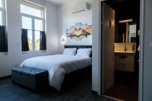 a bedroom with a large white bed and a window at SEE - Gare de Marly in Valenciennes