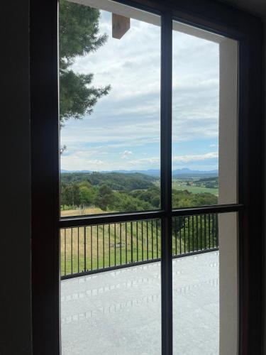 a window with a view of the countryside seen through it at Vineyard Escape Herbersteinova klet in Juršinci