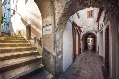 an alley with stairs and an archway in a building at Ravello House in Ravello