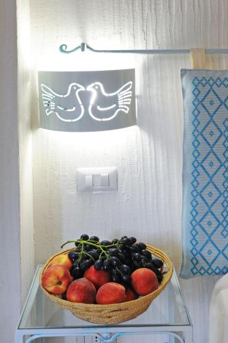 a basket of fruit on a glass shelf in a refrigerator at Alghero Sunrise in Alghero