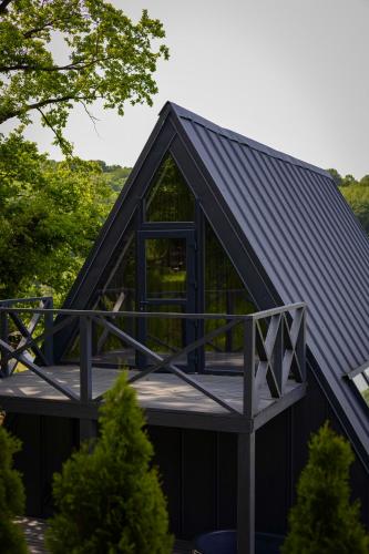 a house with a black roof and a deck at Lav inn Polyana Затишок in Polyana