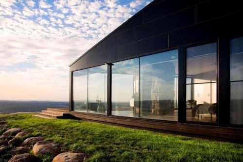 a house on top of a hill with glass windows at Sky High- iconic ridge-top retreat in Hepburn Springs