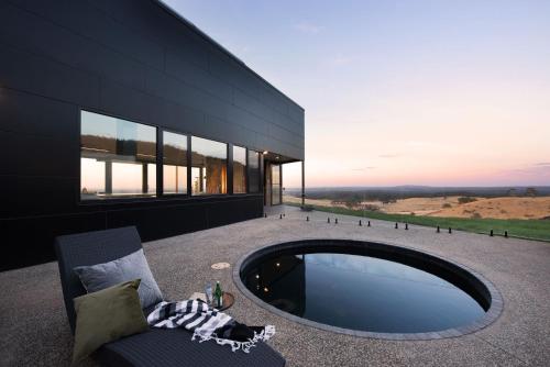 a large black building with a pool in front of it at Sky High- iconic ridge-top retreat in Hepburn Springs