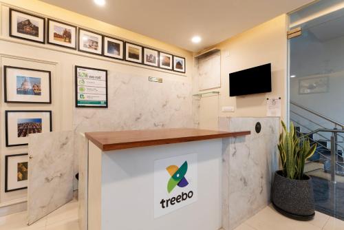 an office with a reception desk and a tv at Treebo Memories Inn in Bengaluru