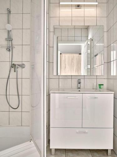 a white bathroom with a shower and a sink at Pałac Potockich w Będlewie in Będlewo