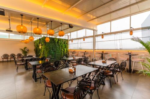 a restaurant with tables and chairs and large windows at Treebo Memories Inn in Bengaluru