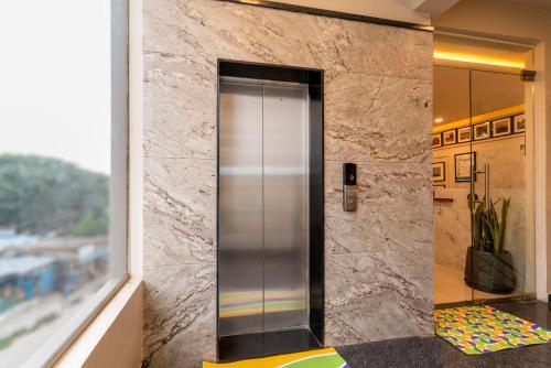 a elevator in a lobby with a stone wall at Treebo Memories Inn in Bengaluru