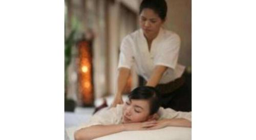 a woman laying on a bed next to a woman in a salon at Hirata Maple Hotel in Izumo