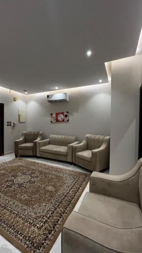 a living room with couches and a rug at شقة فندقية بمجمع هوازن السكني in Ash Sharāʼi‘