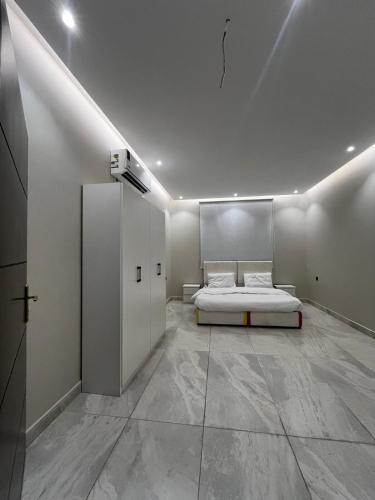 a white room with a bed and a wall at شقة فندقية بمجمع هوازن السكني in Ash Sharāʼi‘