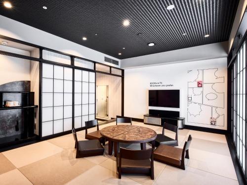 a room with a table and chairs and a television at IN THE LIBRARY hotel and books TOKOROZAWA - Opening in 15th July 2025 in Tokorozawa