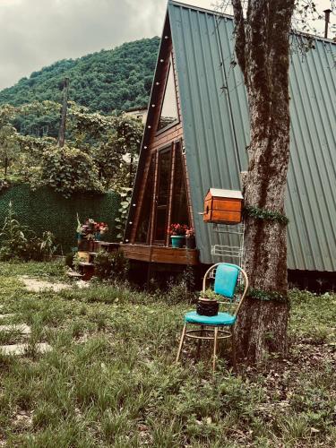 a chair sitting next to a tree next to a house at Twins in Keda