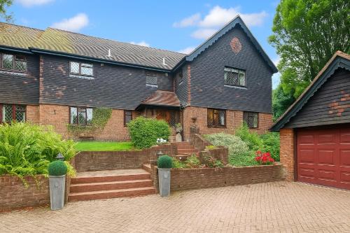a brick house with a red garage at Traditional English house TravellerAwards2026 in Brighton & Hove