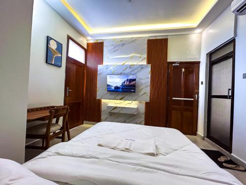 a bedroom with a bed and a desk in it at GEMSON HOMEs in Dar es Salaam