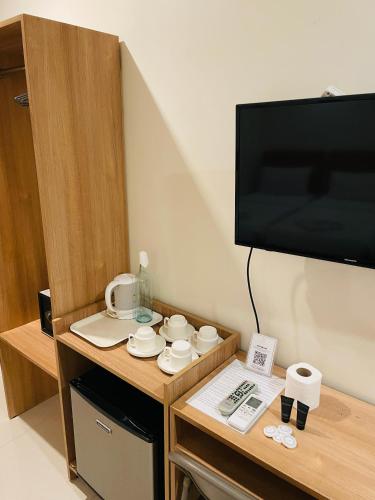 a room with a tv and a table with cups and dishes at Rublin Hotel Cebu in Cebu City