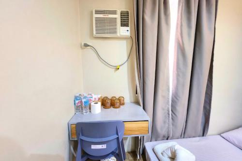 a small room with a blue desk and a window at DLT Suites Cebu powered by Cocotel in Minglanilla