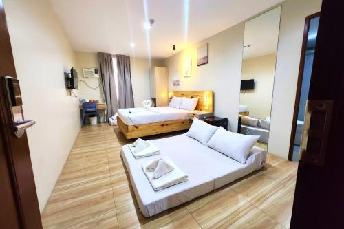 a hotel room with a bed and a mirror at DLT Suites Cebu powered by Cocotel in Minglanilla