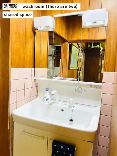 a bathroom with a sink and a mirror at TAKIO 5 guesthouse in Higashi-osaka