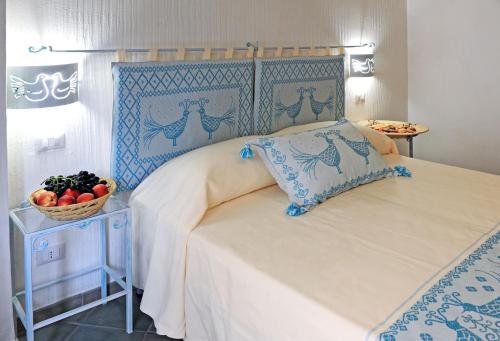 a bedroom with a bed and a bowl of fruit on a table at Alghero Sunrise in Alghero