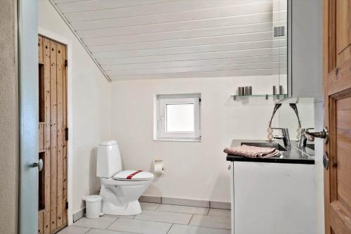a white bathroom with a toilet and a sink at 302-Harboore-Fourmivej-74 in Harboør