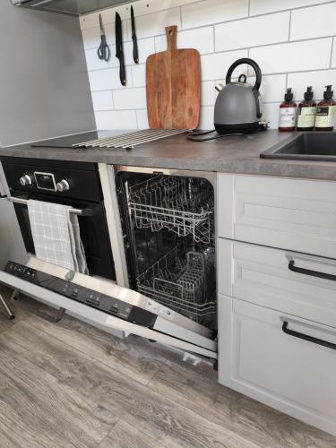 an oven with its door open in a kitchen at PaprikanTiny House in Uppsala