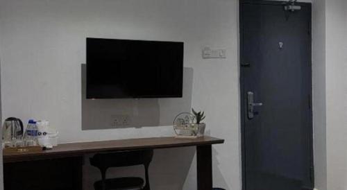 a room with a desk with a television on a wall at Hotel Zamburger Bentong in Bentong