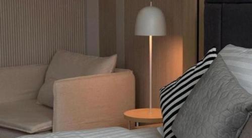 a living room with a couch and a table with a lamp at Hotel Zamburger Bentong in Bentong
