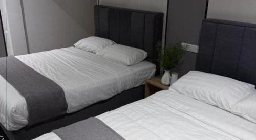 two beds in a small room withskirts at Hotel Zamburger Bentong in Bentong