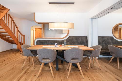 a dining room with a wooden table and chairs at Apparthotel AlpenChalet in Neukirchen am Großvenediger
