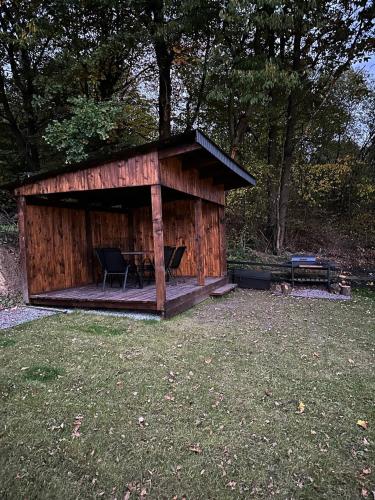 a small wooden cabin with a table and a bench at Lav inn Polyana Затишок in Polyana