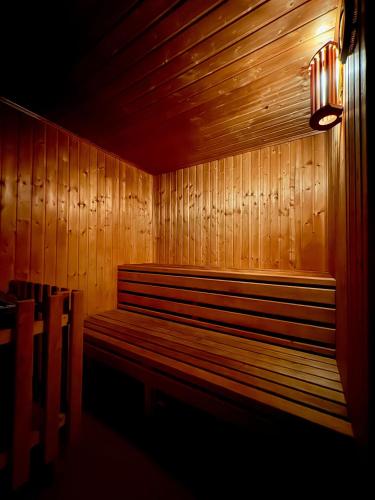 a wooden bench in a room with a light on it at Sklepní apartmán se saunou in Plzeň