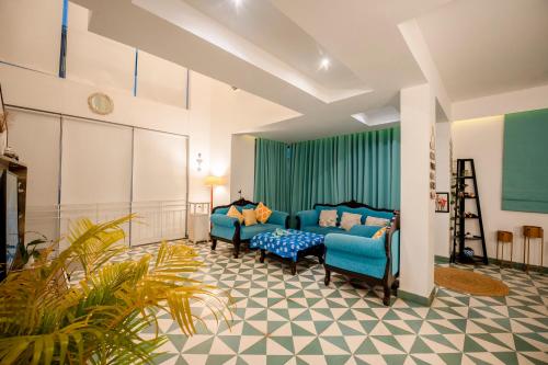 a living room with two blue chairs and a couch at HideAway 2BHK Duplex Villa, North Goa (STU) in Mapusa