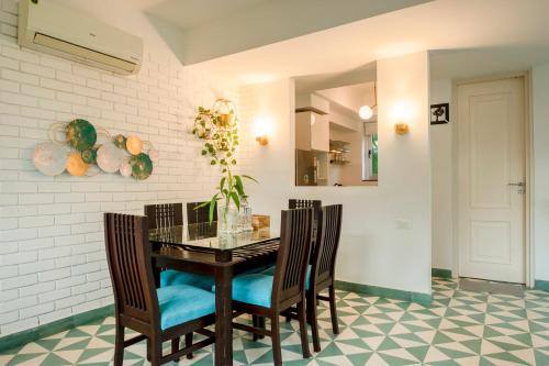 a dining room with a glass table and chairs at HideAway 2BHK Duplex Villa, North Goa (STU) in Mapusa