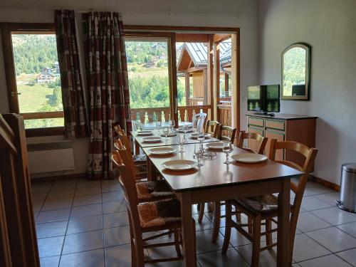 a dining room with a long table and chairs at Grand appartement pour famille ou groupe en montagne - SKI- in Saint-François-Longchamp