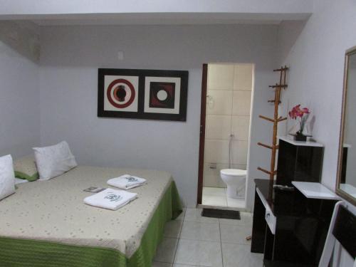 a small bedroom with a bed and a bathroom at Hotel Araguaia Goiânia in Goiânia